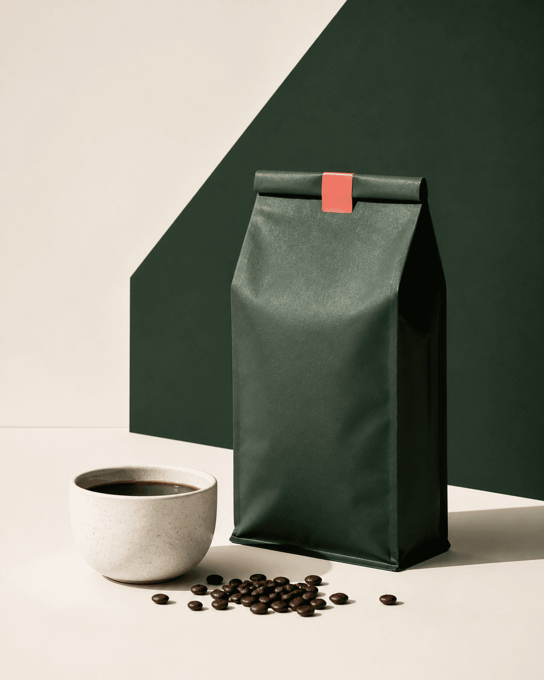 Forest-green coffee bag beside a ceramic cup